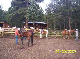 Saddling horses at Clarks Fork Camp corral